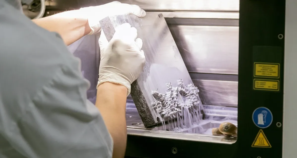 Pièce en cours de démoulage sur une imprimante 3D SLS, chez un partenaire industriel